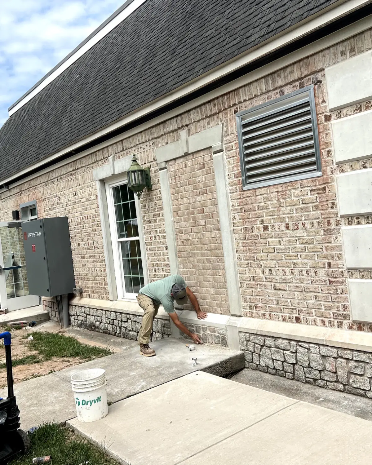 Tudi Stone Masonry setting a cast stone sill into a brick wall
